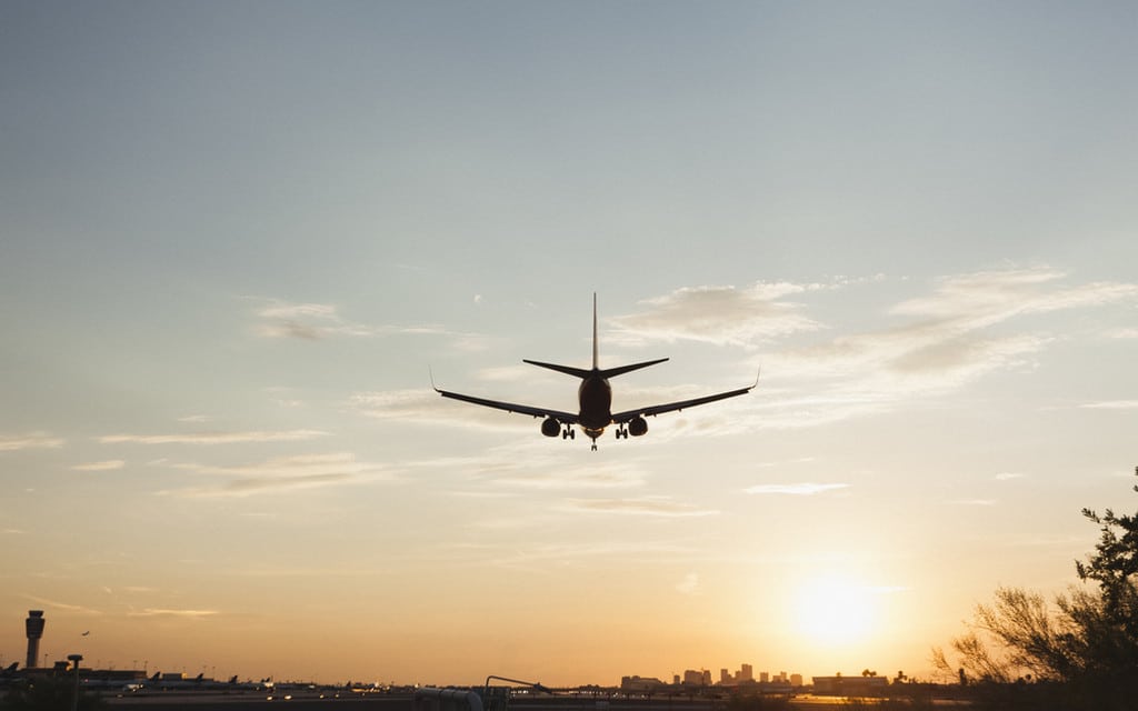 An aircraft on final approach at sunset
